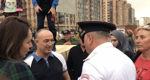 Активисты на сходе в Каспийске 11 сентября беседуют с полицейским. Фото Патимат Махмудовой для "Кавказского узла".