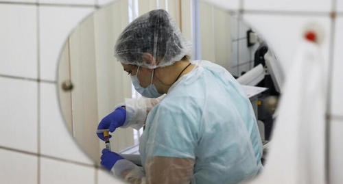 Медик при работе с образцом крови, взятым во время тестирования на коронавирусную болезнь (КОВИД-19) и антитела в московской клинике. Фото: REUTERS/Maxim Shemetov