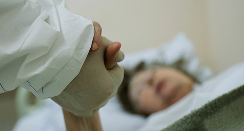 Медицинский работник держит за руку пациента. Фото: REUTERS/Maxim Shemetov