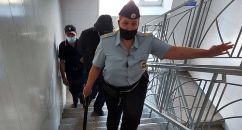 Сотрудники полиции сопровождают Александра Гусева в здании суда. Фото: Управление судебного департамента в Новосибирской области