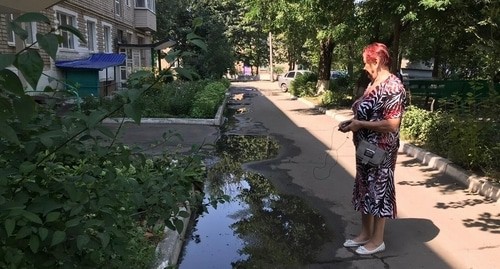 Жительница Красного Сулина смотрит на прорыв канализации во дворе жилого дома. 1 августа 2021 года. Фото Вячеслава Прудникова для "Кавказского узла". Жительница Красного Сулина смотрит на прорыв канализации во дворе жилого дома. 1 августа 2021 года. Фото Вячеслава Прудникова для "Кавказского узла".