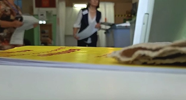 Член УИК в Волгограде засовывает бюллетень в КОИБ. Стоп-кадр видео https://spravedlivo.ru/11514310 Член УИК в Волгограде засовывает бюллетень в КОИБ. Стоп-кадр видео https://spravedlivo.ru/11514310