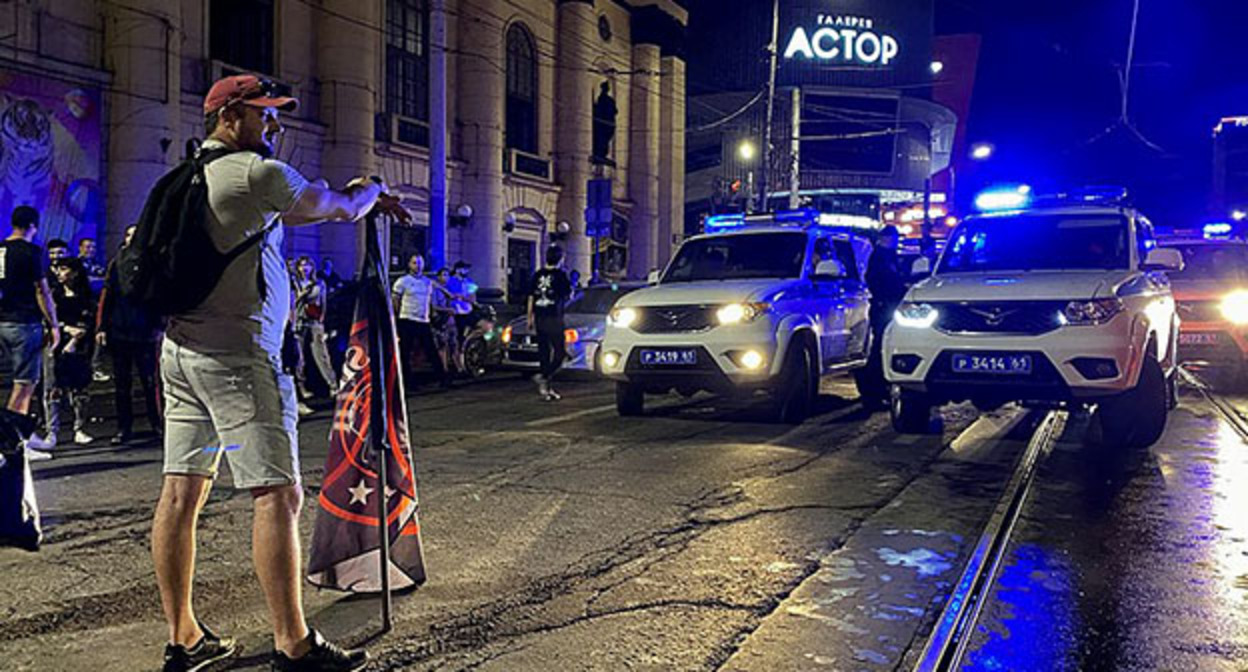 Мужчина с флагом ЧВК "Вагнер" напротив полицейских машин на Буденновском проспекте в Ростове-на-Дону. Фото: Fargoh. https://ru.wikipedia.org Мужчина с флагом ЧВК "Вагнер" напротив полицейских машин на Буденновском проспекте в Ростове-на-Дону. Фото: Fargoh. https://ru.wikipedia.org