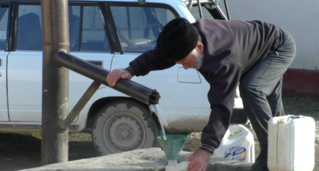 Житель Умашаула набирает воду. Стоп-кадр видео "Кавказского узла", https://youtu.be/X45ODib0-Mg
