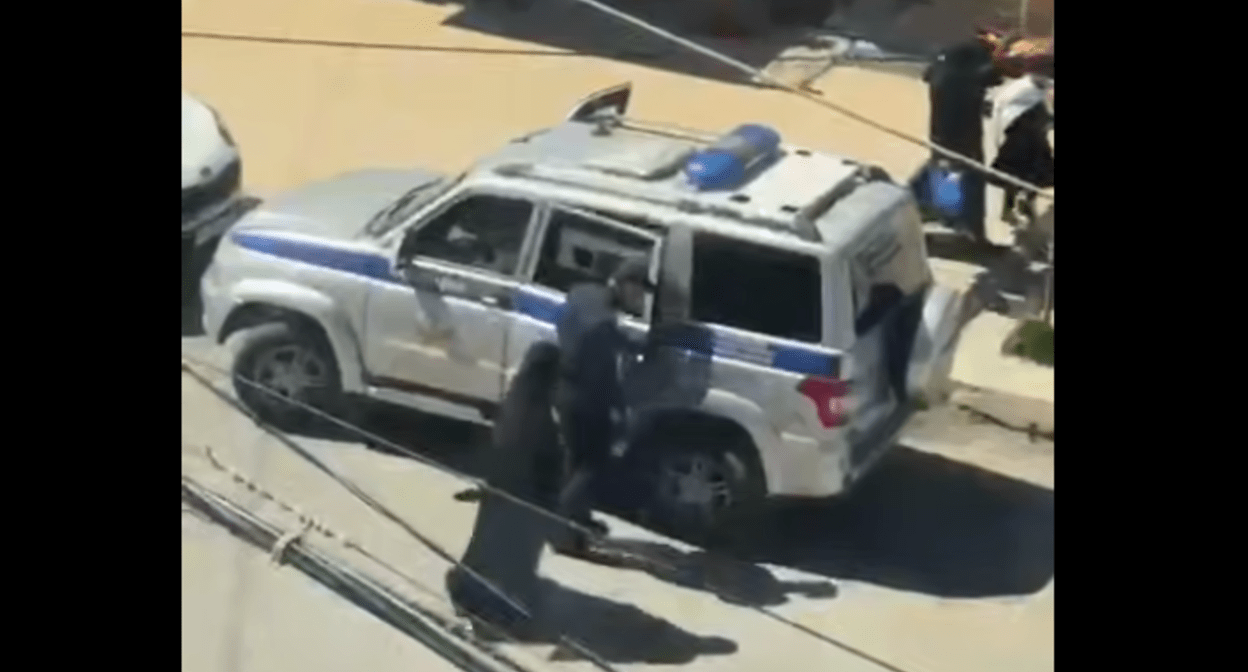 Силовик сажает мусульманку в машину. Стоп-кадр видео из Telegram-канала "Совесть Дагестана" от 20.04.25, https://t.me/sovestdagestana/38592