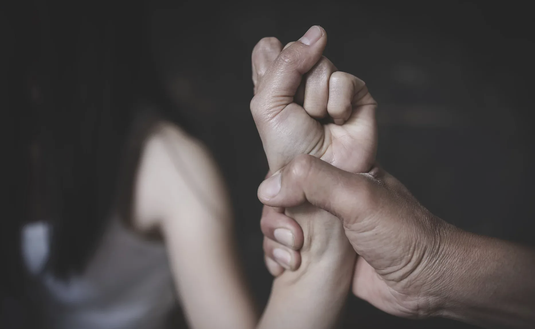 Мужчина держит руку женщины. Скриншот фото с сайта https://nso.gov.mt/crime/domestic-violence-2023/.
