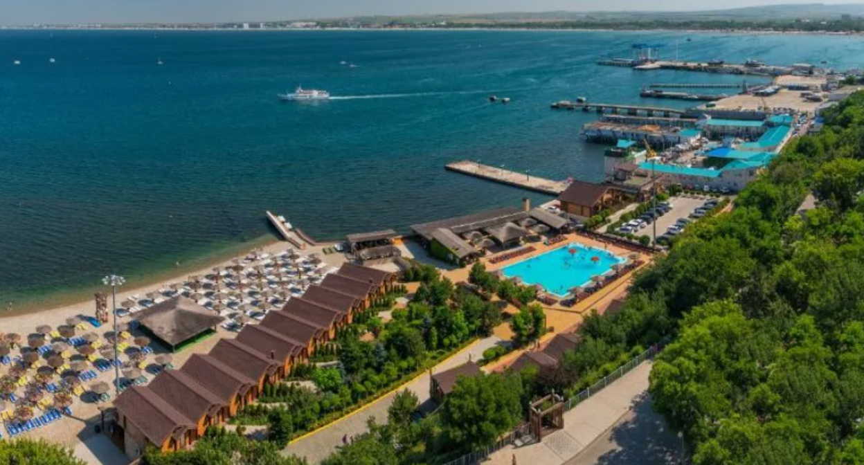 Побережье Анапы. Вид на отель "Золотая бухта". Скриншот фото с сайта Booking.com? https://www.booking.com/hotel/ru/zolotaya-buhta-anapa.ru.html?aid=357027&label=yan104jc-1DCAsowgFCFHpvbG90YXlhLWJ1aHRhLWFuYXBhSAlYA2ipAYgBAZgBIbgBF8gBDNgBA-gBAYgCAagCA7gCyrWWwwbAAgHSAiQwNzk1YjBkZi0wMmFhLTQ2NzgtODI5My1lZDcyODY3MDVjYTLYAgTgAgE&sid=60d6ae9fc20b1b4e68b76e1e2a82fcc3&dist=0&keep_landing=1&sb_price_type=total&type=total&force_referer=https%3A%2F%2Fyandex.ru%2Fimages%2Fsearch%3Ffrom%3Dtabbar%26img_url%3Dhttps%253A%252F%252Fpriroda.club%252Fuploads%252Fposts%252F2022-01%252F1643398006_6-priroda-club-p-plyazh-zolotaya-bukhta-anapa-priroda-krasi-6.jpg%26lr%3D222%26pos%3D0%26rpt%3Dsimage%26text%3D%25D0%25B0%25D0%25BD%25D0%25B0%25D0%25BF%25D0%25B0%2520%25D0%25BF%25D0%25BE%25D0%25B1%25D0%25B5%25D1%2580%25D0%25B5%25D0%25B6%25D1%258C%25D0%25B5%2520%25D0%25BE%25D1%2582%25D0%25B5%25D0%25BB%25D0%25B8