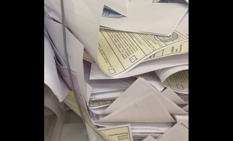 Пачки бюллетеней в избирательной урне. Стоп-кадр видео из Telegram-канала Евгения Федяева от 12.09.25, https://t.me/fedyaev_evgenij/2580.