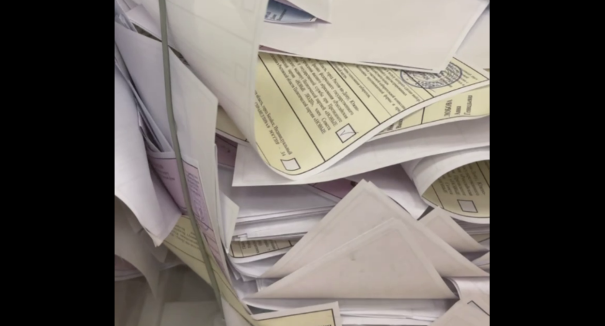 Пачки бюллетеней в избирательной урне. Стоп-кадр видео из Telegram-канала Евгения Федяева от 12.09.25, https://t.me/fedyaev_evgenij/2580.
