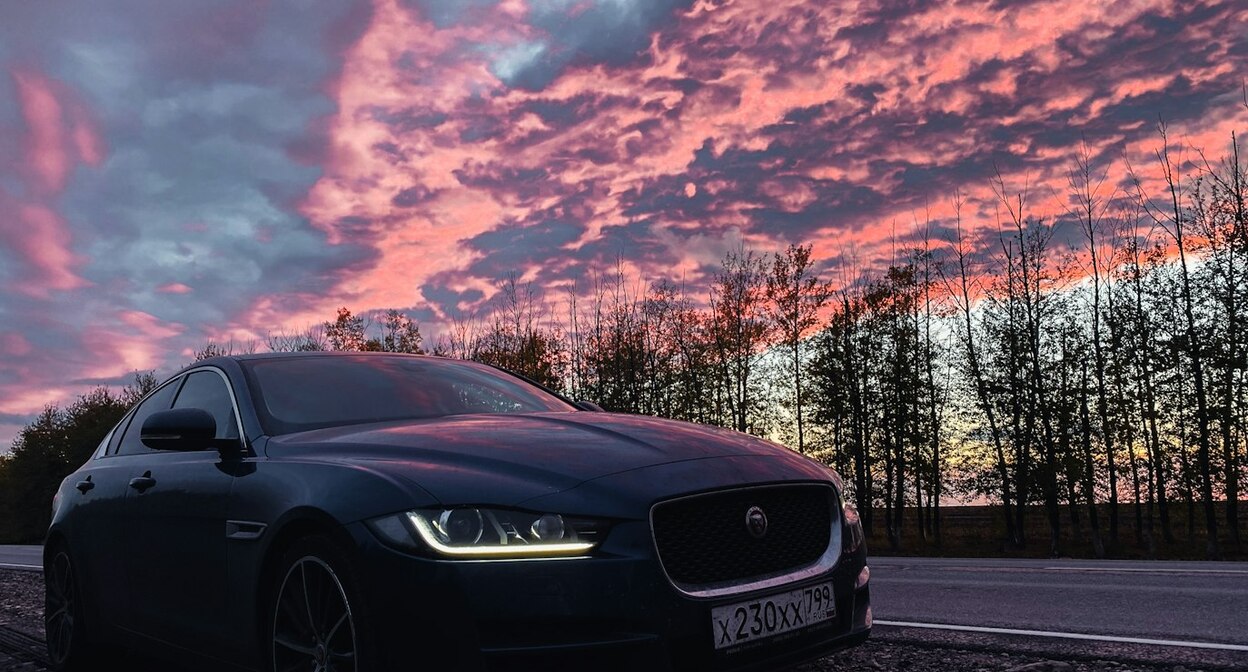 Автомобиль с включенными фарами на дороге. Фото: Alexander Popovkin / Unsplash.com 