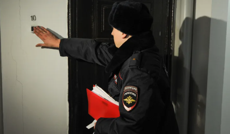 Сотрудник полиции звонит в дверь. Стоп-кадр видео https://www.5-tv.ru/player/458191.