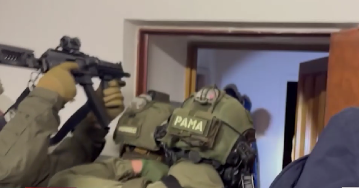 Силовики входят в квартиру одного из задержанных. Стоп-кадр видео https://t.me/kommersant/98586 от 30.12.25.