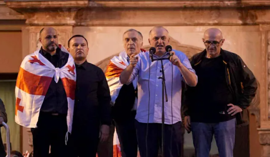 Слева направо: Иракли Надирадзе, Паата Манжгаладзе, Паата Бурчуладзе, Муртаз Зоделава,  Лаша Беридзе на акции 04.10.25. Скриншот фото "Интерпрессньюс" https://www.interpressnews.ge/ru/article/174819-po-delu-4-oktiabria-paata-burchuladze-murtaz-zodelava-iraklii-nadiradze-lasha-beridze-i-paata-mandzhgaladze-prigovoreny-k-7-tornike-mchedlishvili-nika-gventsadze-iraklii-chkhvirkiia-k-5-a-iraklii-shaishmelashvili-k-2-godam-lisheniia-svobody.
