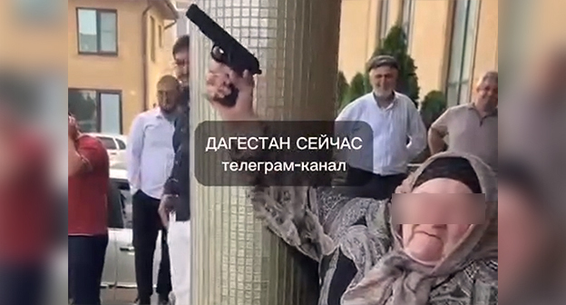 Пожилая жительница Хасавюрта производит выстрел из пистолета во время свадьбы. Кадр из видео https://www.instagram.com/p/DapuiBgM6xA (деятельность компании Meta (владеет Facebook, Instagram и WhatsApp) запрещена в России)
