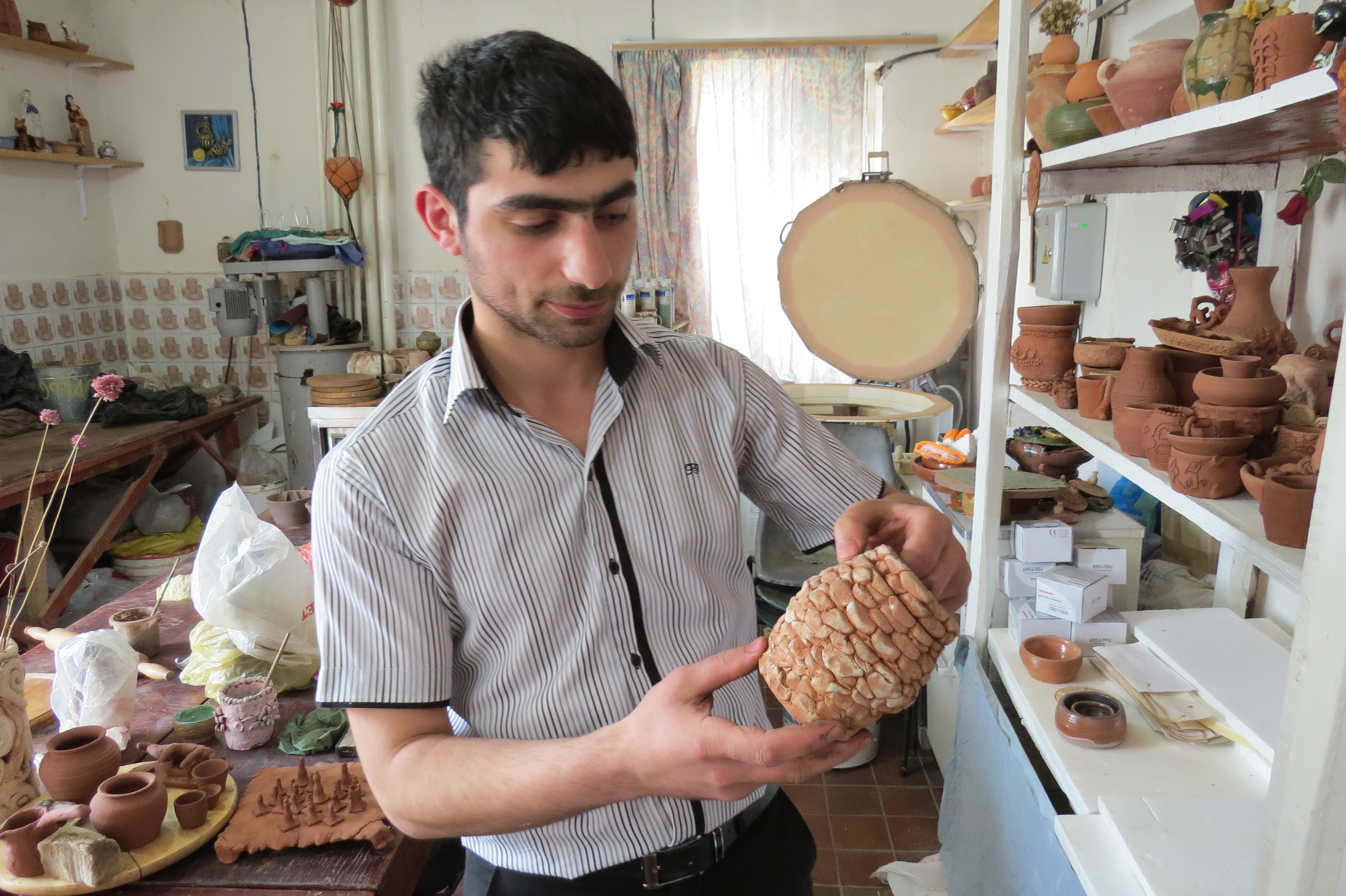 Сероб показывает одну из работ малышей, которые самостоятельно вылепили их кружочков стену небольшой чаши Сероб показывает одну из работ малышей, которые самостоятельно вылепили их кружочков стену небольшой чаши