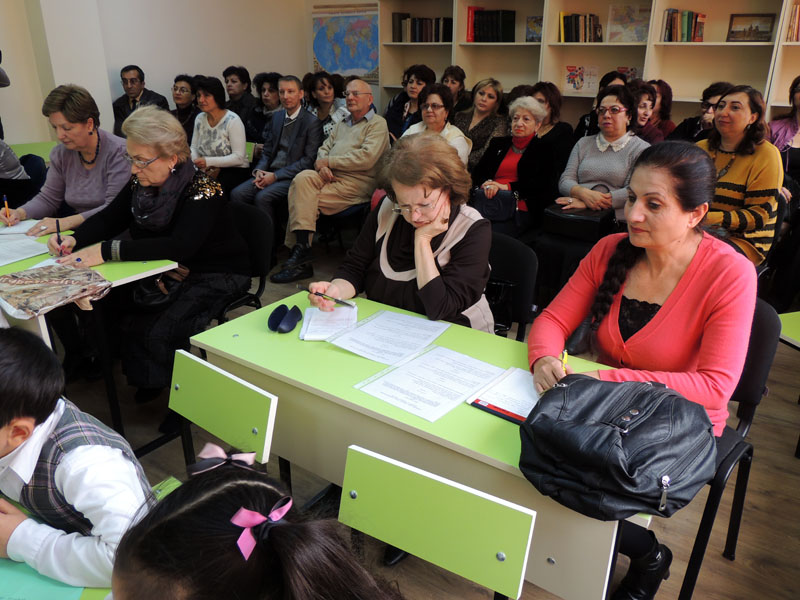 Представители министесрст просвещения Армении и НКР записывают в своих блокнотах ошибки, выявленные во время прослушивания урока.